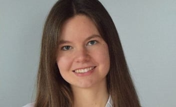 Porträtaufnahme einer lächelnden jungen Frau mit langen braunen Haaren; Beitragsbild für den Erfahrungsbericht über ein Praktikum bei PerformaNat.