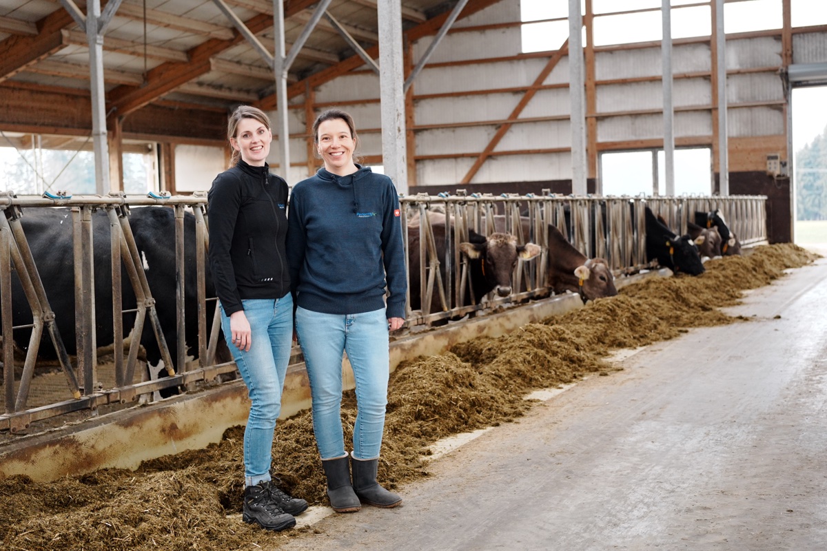 Katharina Schrapers und Julia Rosendahl von PerformaNat mit Milchkühen im Stall